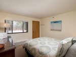 main bedroom featuring queen sized bed and great wooded views